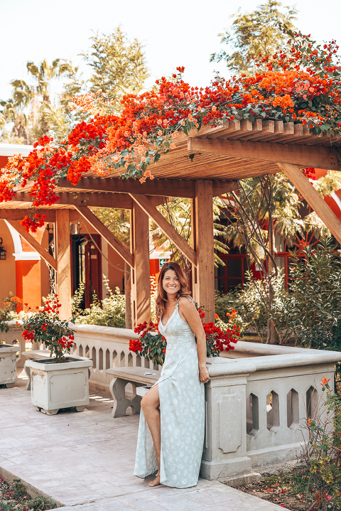 Ashley standing in the garden under some blooming bougainvilleas