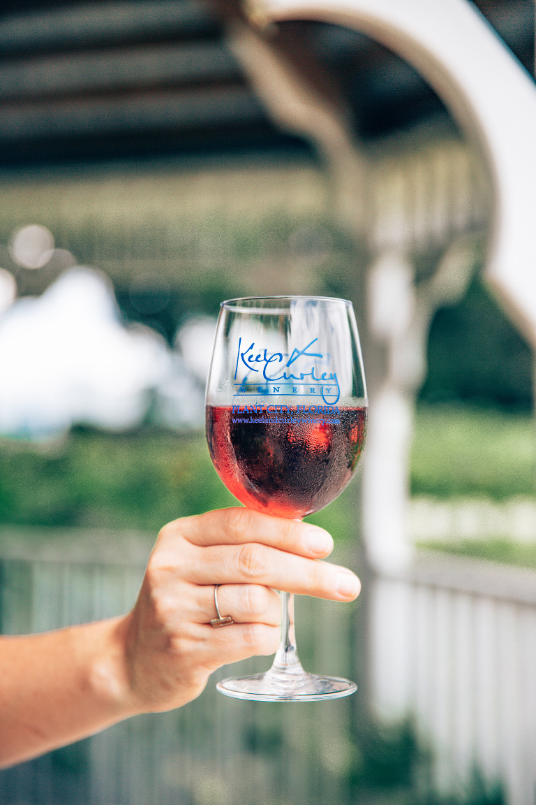 A lovely glass of dry blueberry wine, in a branded Keel & Curley Winey glass. So cold, you can see the condensation on the bottom of the glass.